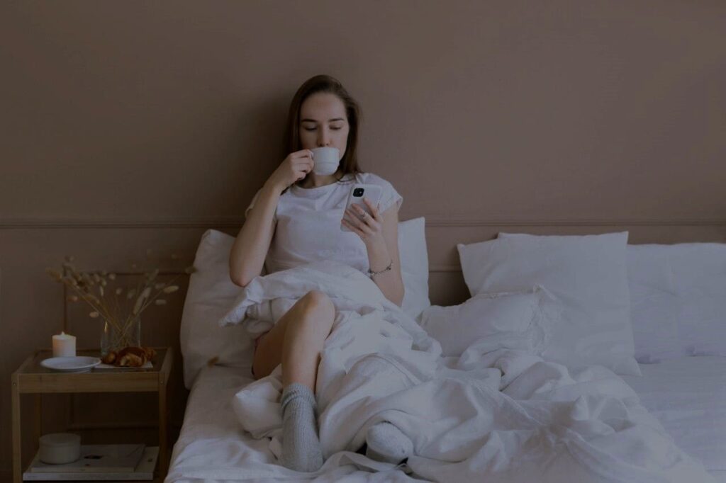 Cover picture: A woman drinks coffee in the evening in her bed